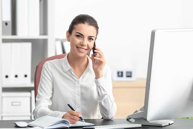 digital bookkeeping with smiling woman on the phone in an office